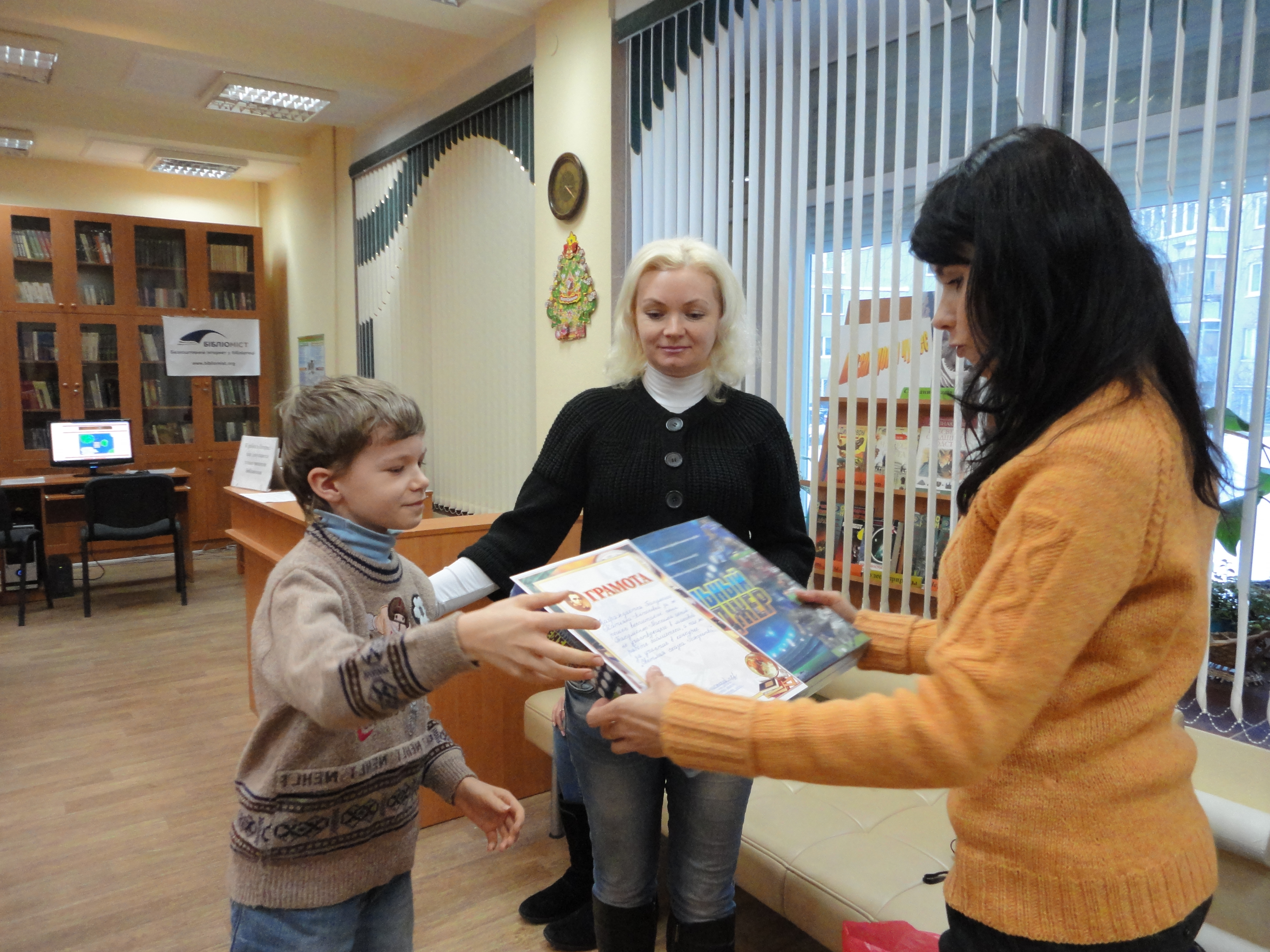 Максим Бакуменко разом з мамою отримує приз за активну участь у житті бібліотеки.